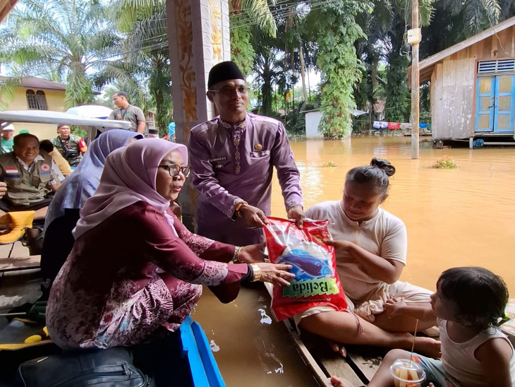 Naik Sampan, Wakil Bupati Kampar Serahkan Bantuan untuk Warga Terdampak Banjir di Desa Buluh Cina
