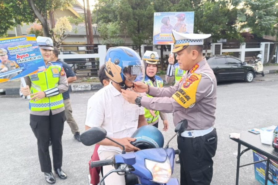 Dirlantas Polda Riau Pasang Helm dan Beri Souvernir untuk Pengendara